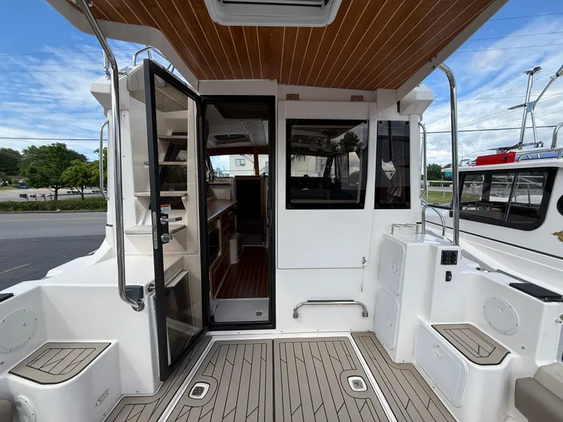 Slide: The Image of 2023 Cutwater C-32 CB boat interior with open door, showcasing modern design and wood accents. - 14