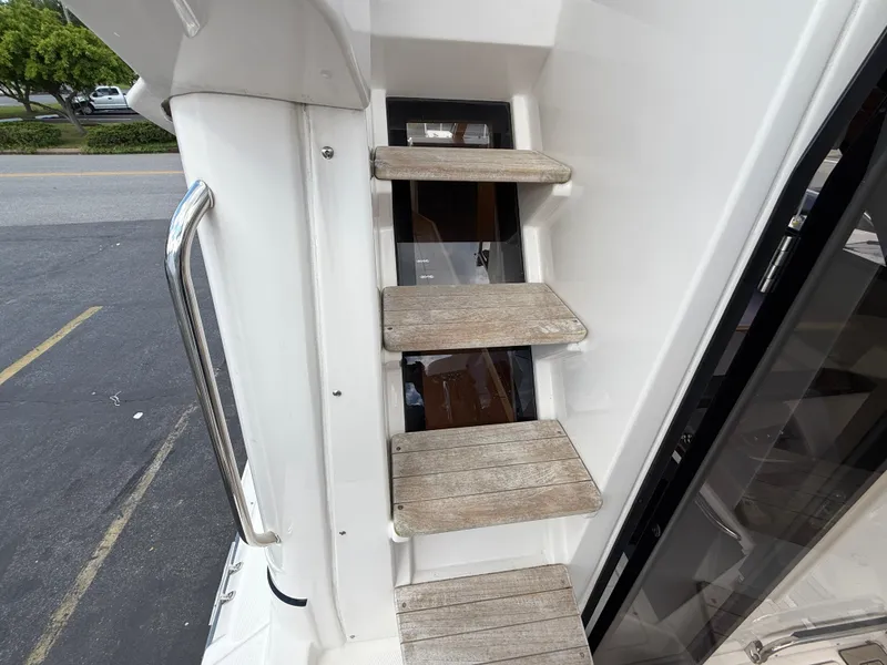 Slide: The Image of Staircase on 2023 Cutwater C-32 CB boat, featuring wooden steps and metal handrail. - 15