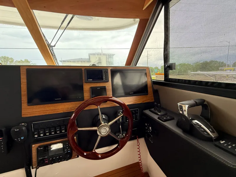 Slide: The Image of 2023 Cutwater C-32 CB helm with dual screens and wooden steering wheel. - 23
