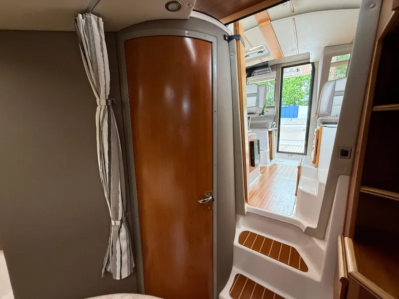Slide: The Image of 2023 Cutwater C-32 CB interior with wooden door, steps, and modern design. - 28