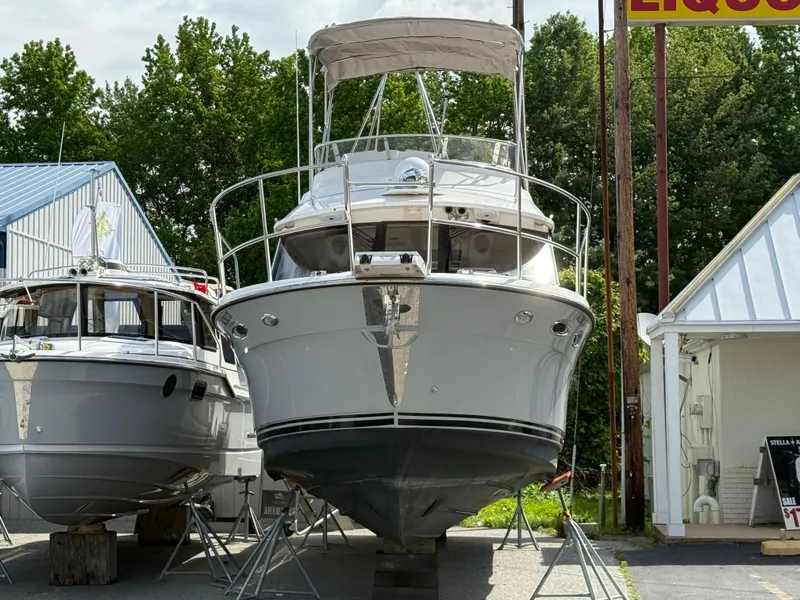 Slide: The Image of 2023 Cutwater C-32 CB boat on display, front view, outdoors, with trees and buildings in background. - 3