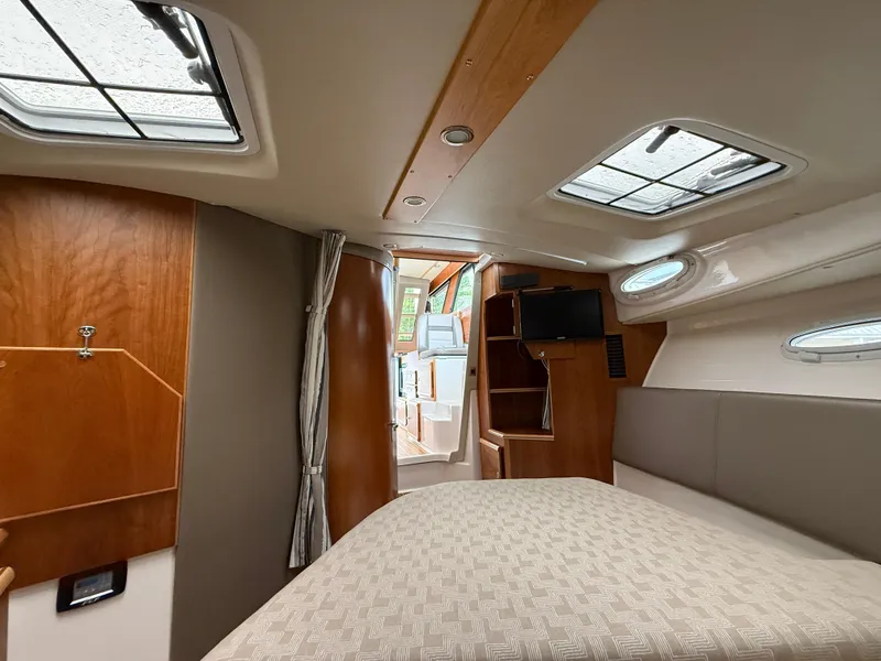 Slide: The Image of 2023 Cutwater C-32 CB cabin interior with bed, wood accents, and skylights. - 31