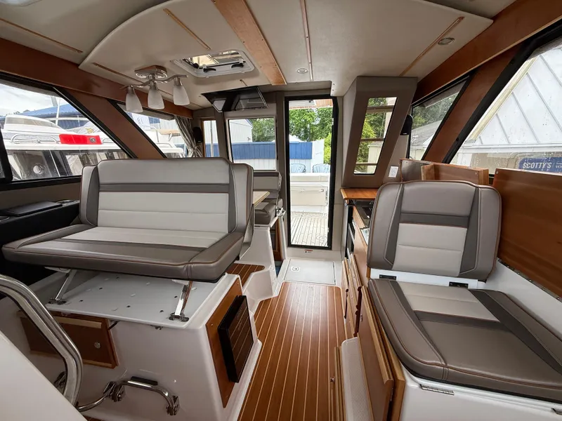 Slide: The Image of 2023 Cutwater C-32 CB interior with modern seating and wood accents. - 33