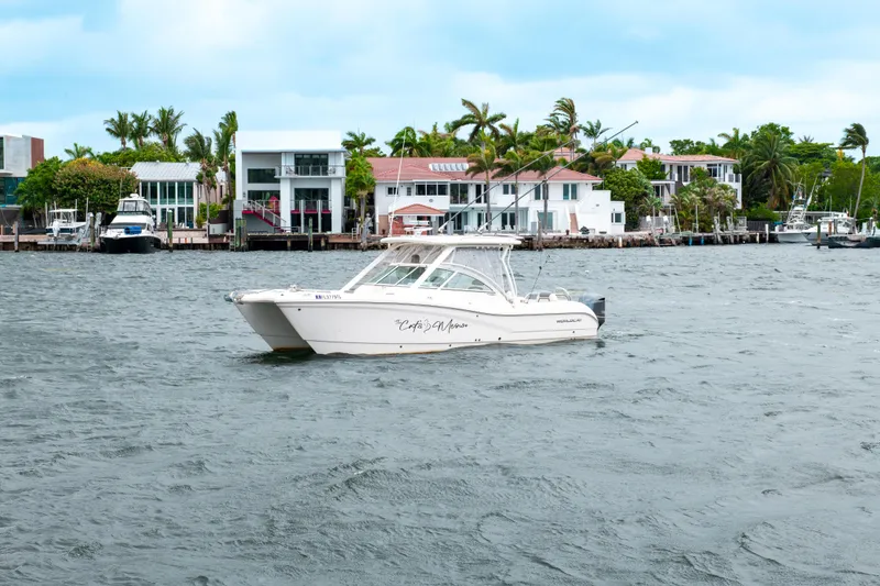 Slide: The Image of 2019 World Cat 296DC boat on water near waterfront homes. - 14