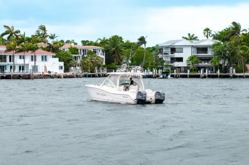 Slide: The Image of 2019 World Cat 296DC boat cruising near waterfront homes with palm trees. - 17