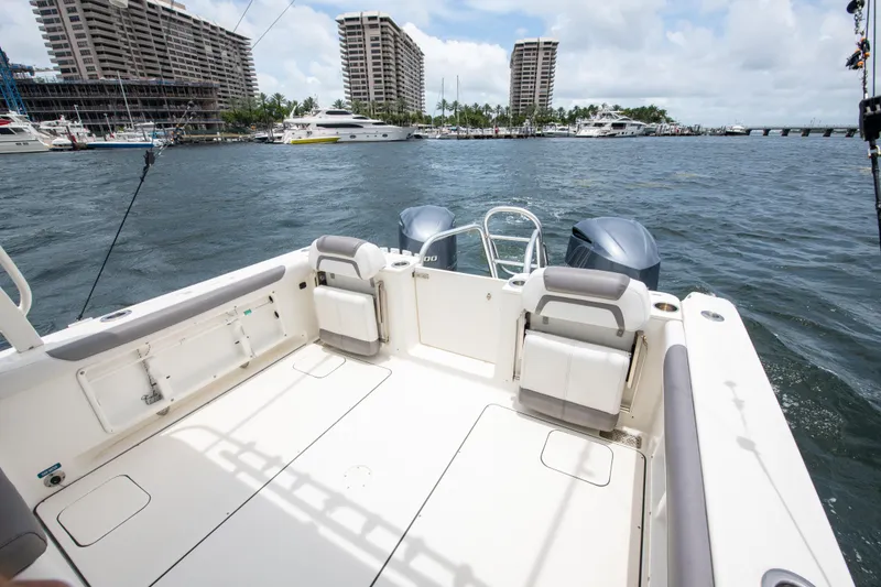 Slide: The Image of 2019 World Cat 296DC boat with spacious deck, docked near waterfront buildings. - 26