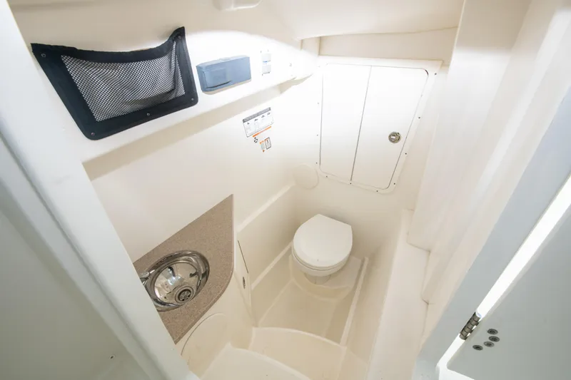 Slide: The Image of 2019 World Cat 296DC boat bathroom with sink, toilet, and storage compartment. - 31