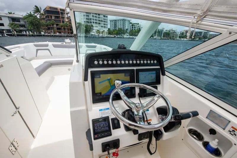 Slide: The Image of 2019 World Cat 296DC boat helm with navigation screens and steering wheel on water. - 36