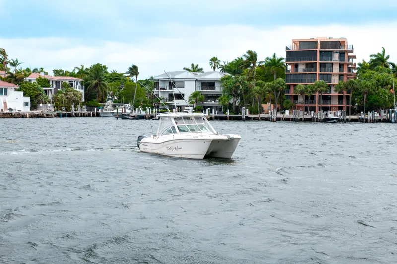 Slide: The Image of 2019 World Cat 296DC boat cruising near waterfront homes. - 4