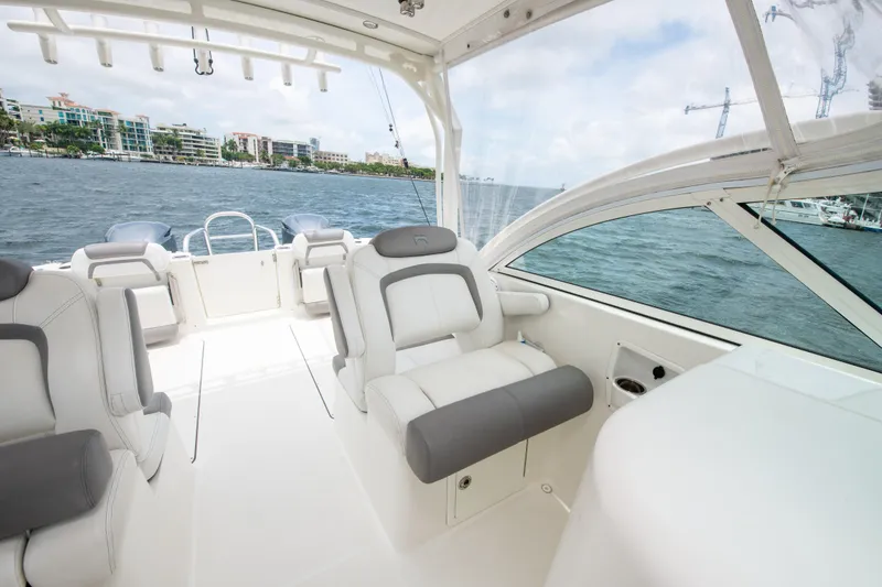 Slide: The Image of 2019 World Cat 296DC boat interior with plush seating, overlooking a scenic waterfront. - 42