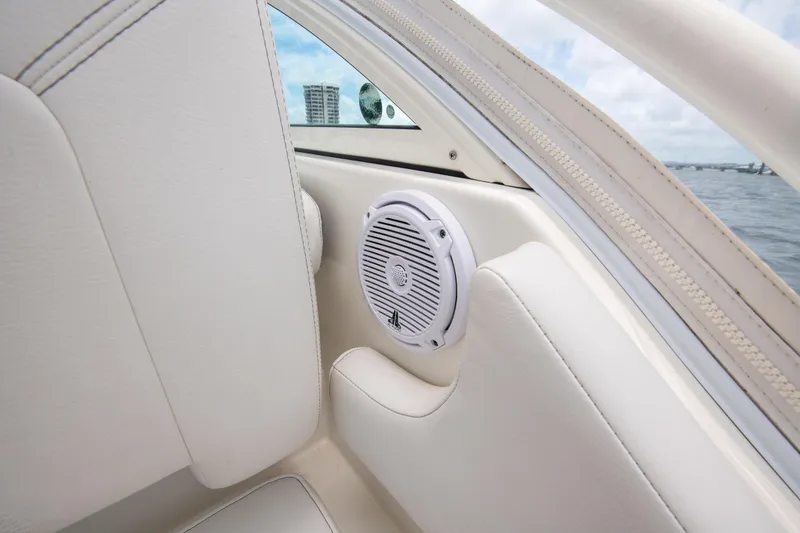 Slide: The Image of 2019 World Cat 296DC boat interior with speaker, white upholstery, and water view. - 45