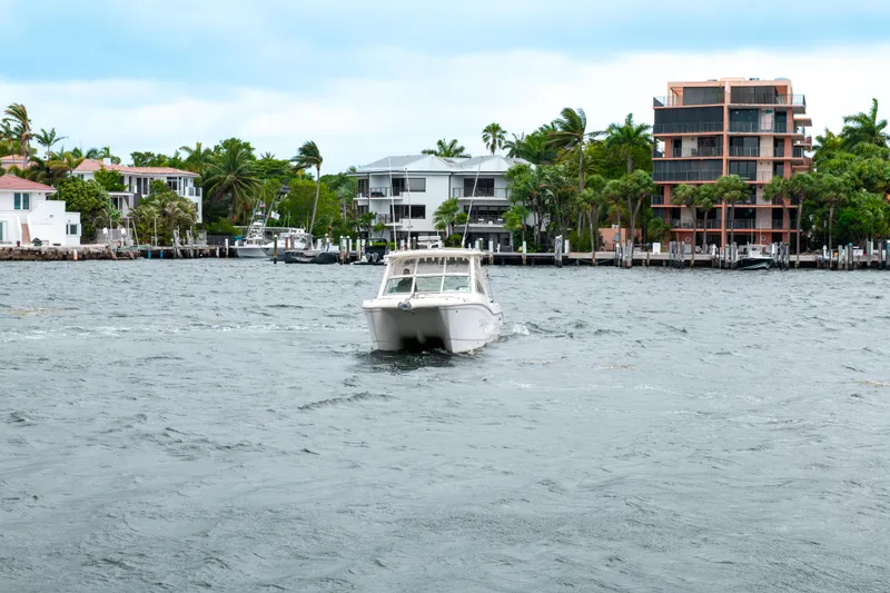 Slide: The Image of 2019 World Cat 296DC boat cruising near waterfront homes. - 7