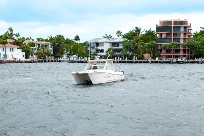 Slide: The Image of 2019 World Cat 296DC boat cruising near waterfront homes. - 9
