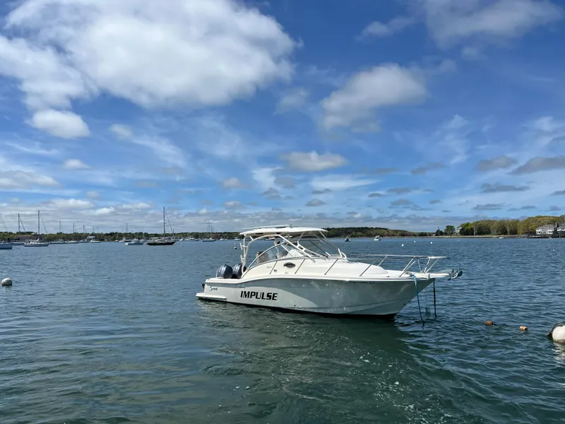 Slide: The Image of 2012 Scout 262 Abaco boat named "Impulse" on calm water under blue sky. - 0