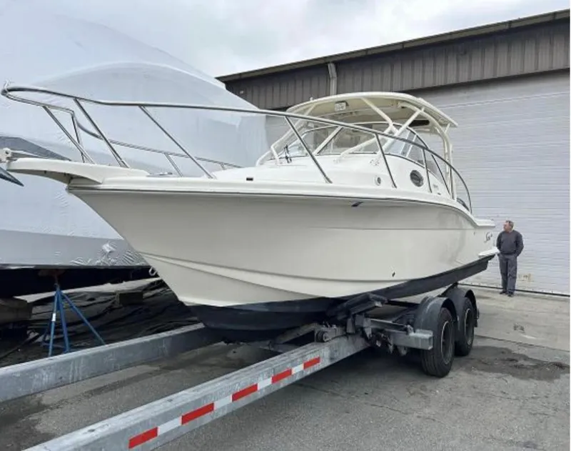 Slide: The Image of 2012 Scout 262 Abaco boat on trailer, parked outdoors near a warehouse. - 1