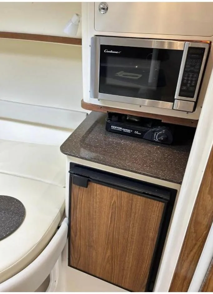 Slide: The Image of Compact kitchen area in a 2012 Scout 262 Abaco boat with microwave and mini fridge. - 15