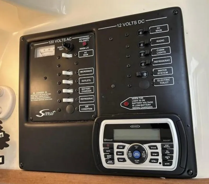 Slide: The Image of Electrical control panel of a 2012 Scout 262 Abaco boat with various switches and a stereo system. - 17