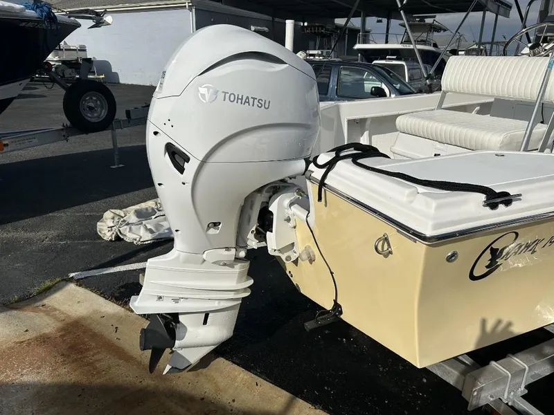Slide: The Image of 2024 C-Hawk 19 Center Console with Tohatsu outboard motor, parked on a trailer. - 4