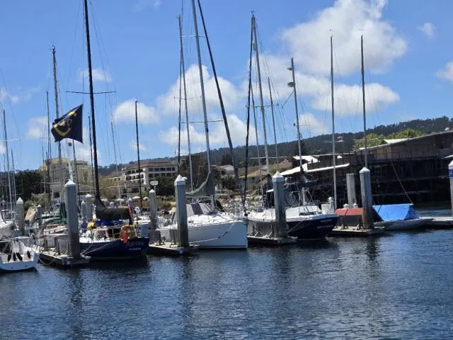 Slide: The Image of Sailboats docked at a marina, featuring a 2002 Beneteau First 36.7 under a clear blue sky. - 17