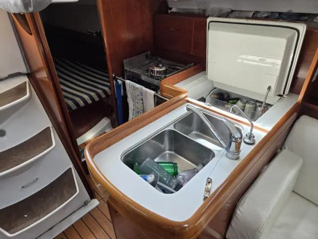 Slide: The Image of Interior of 2002 Beneteau First 36.7 yacht with kitchen sink and striped bedding. - 4