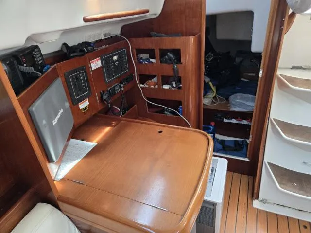 Slide: The Image of Navigation station inside 2002 Beneteau First 36.7 sailboat, featuring wooden cabinetry and equipment. - 5