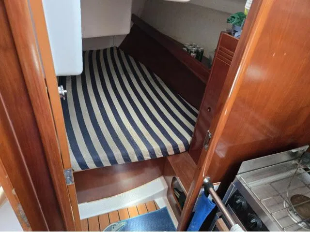 Slide: The Image of Cozy cabin interior of 2002 Beneteau First 36.7 sailboat with striped bedding. - 7