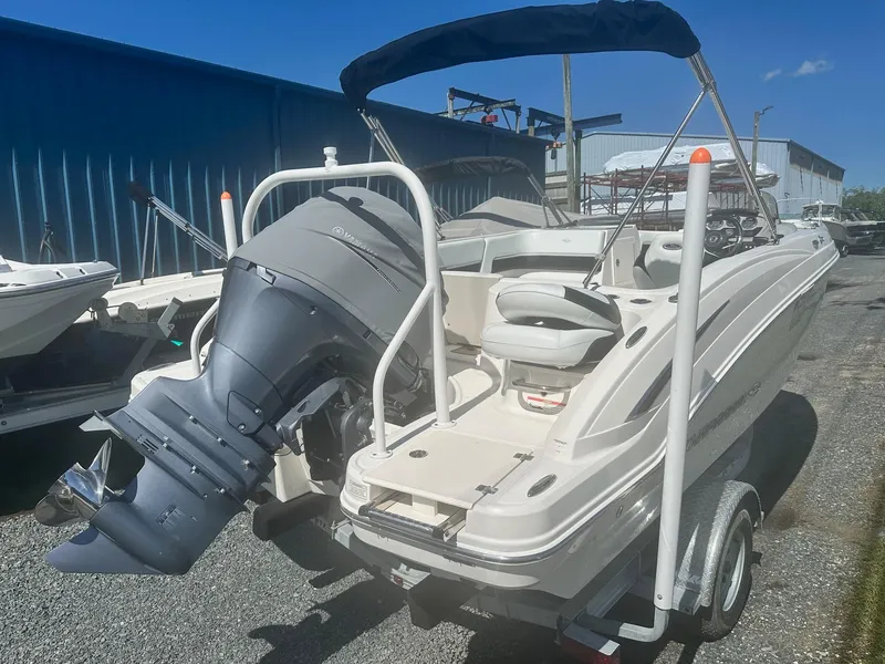 Slide: The Image of 2018 Chaparral 191 Suncoast boat with outboard motor, parked on a trailer. - 3