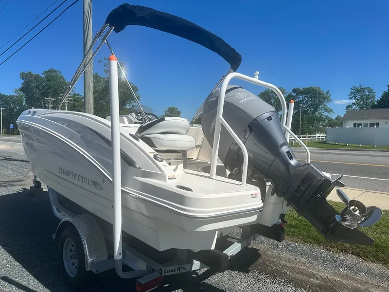 Slide: The Image of 2018 Chaparral 191 Suncoast boat with outboard motor on trailer, parked roadside. - 4