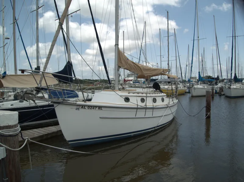 The Image of Sailboat Com-Pac 27-2, 1996 model, docked in a marina with other boats. - 1