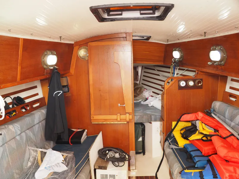 Slide: The Image of Interior of 1996 Com-Pac 27-2 sailboat with wooden cabinetry and seating. - 10