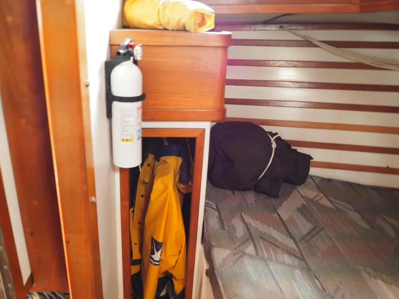 Slide: The Image of Interior of 1996 Com-Pac 27-2 sailboat with fire extinguisher and storage. - 12