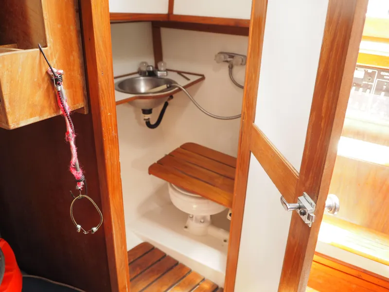 Slide: The Image of 1996 Com-Pac 27-2 sailboat interior with wooden bathroom, sink, and toilet. - 14