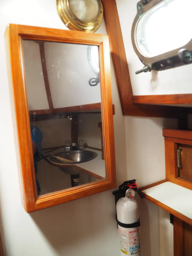 Slide: The Image of Interior of 1996 Com-Pac 27-2 sailboat with mirror, sink, and fire extinguisher. - 15