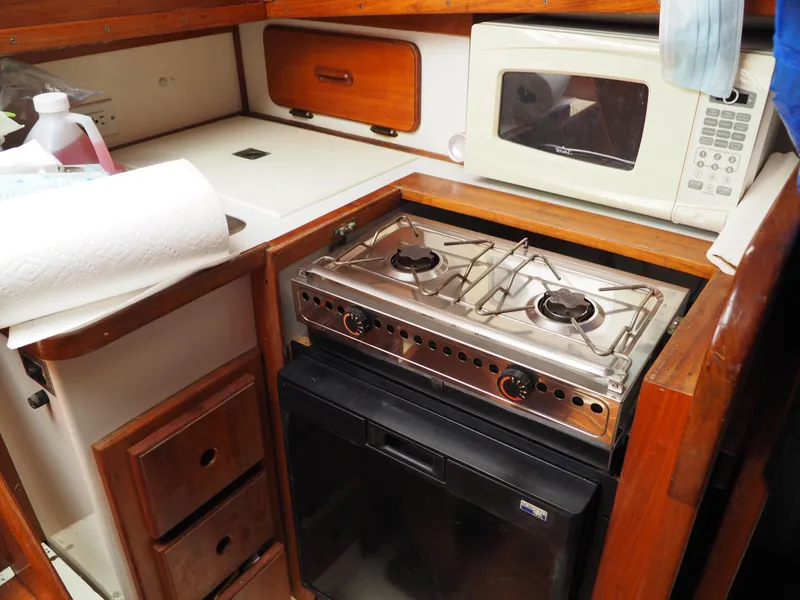 Slide: The Image of Compact kitchen in 1996 Com-Pac 27-2 sailboat with stove, microwave, and storage. - 17