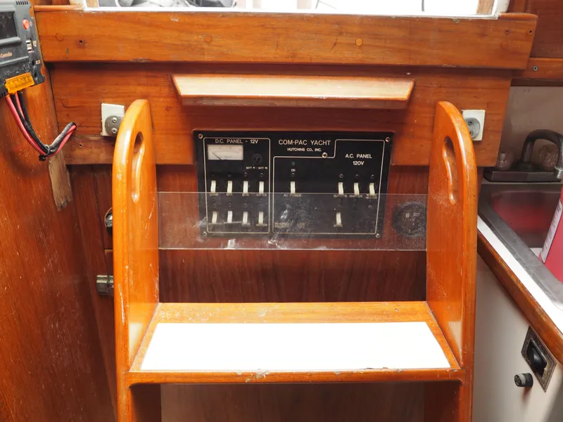 Slide: The Image of 1996 Com-Pac 27-2 yacht electrical panel with wooden frame and switches. - 19