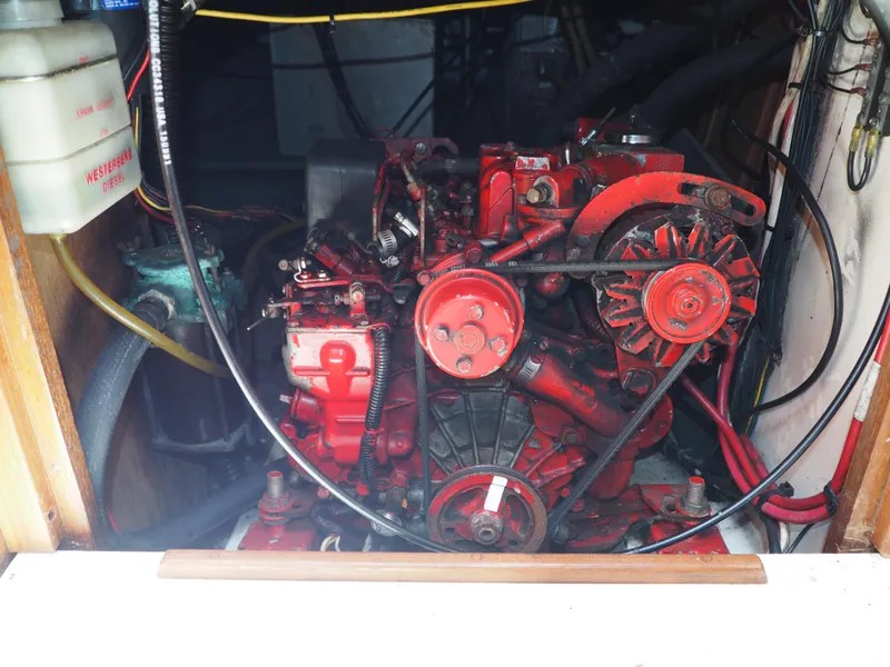 Slide: The Image of Engine compartment of a 1996 Com-Pac 27-2 sailboat, featuring a red marine engine. - 22