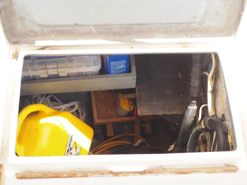 Slide: The Image of Storage compartment of a 1996 Com-Pac 27-2 sailboat with various equipment and supplies. - 25