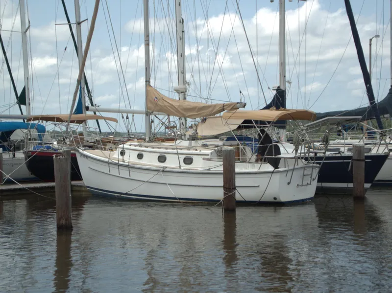 Slide: The Image of 1996 Com-Pac 27-2 sailboat docked in a marina, surrounded by other boats. - 3