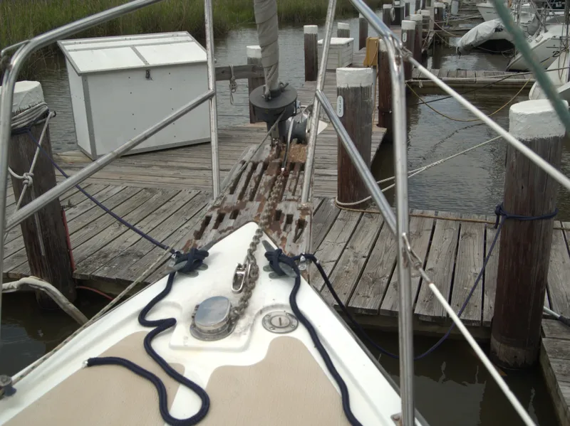 Slide: The Image of Bow of a 1996 Com-Pac 27-2 sailboat docked at a wooden pier. - 5