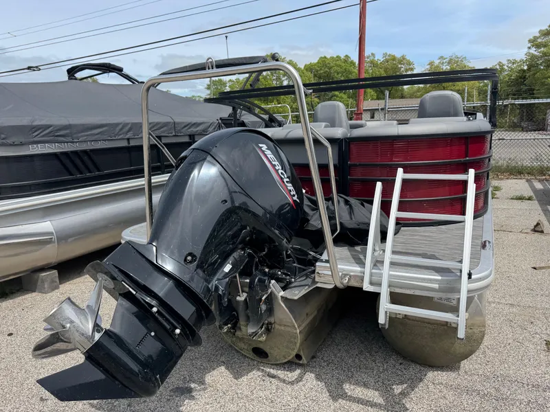 Slide: The Image of 2022 Bennington 22 LSR pontoon boat with Mercury outboard motor, docked outdoors. - 10