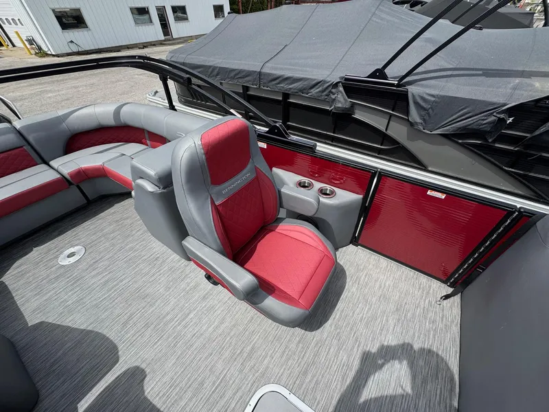 Slide: The Image of 2022 Bennington 22 LSR boat interior with red and gray seating, cup holders, and covered storage. - 5