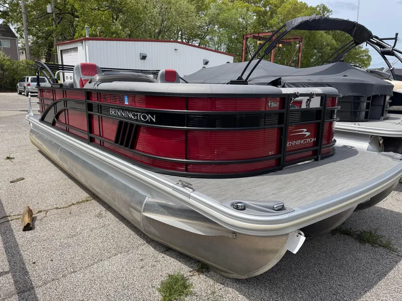 Slide: The Image of 2022 Bennington 22 LSR pontoon boat with red and black design, parked outdoors. - 8