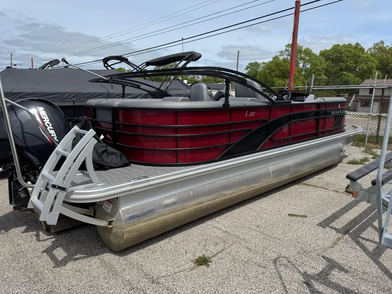 Slide: The Image of 2022 Bennington 22 LSR pontoon boat with red and black design, parked outdoors. - 9
