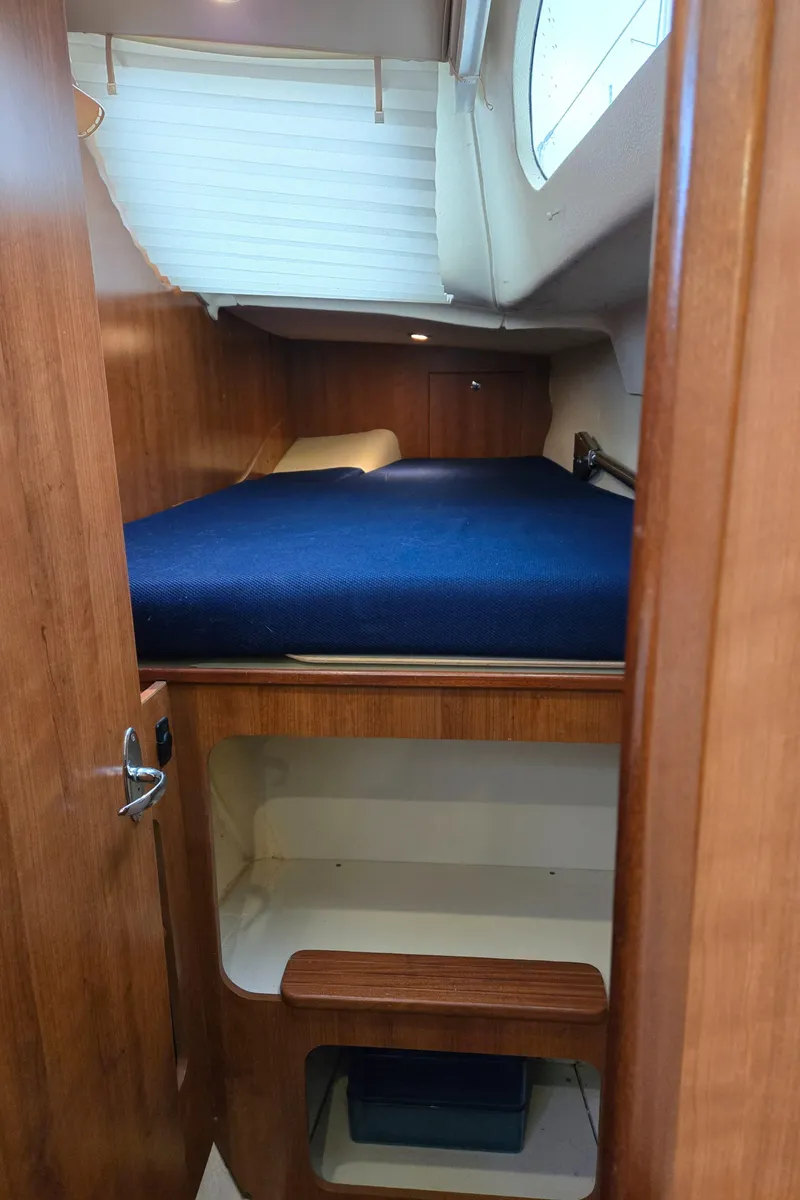 Slide: The Image of 2013 Gemini Legacy 35 cabin interior with wooden finish and blue bedding. - 30