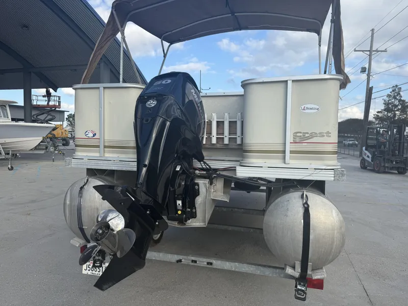 Slide: The Image of 2003 Crest 18 Fisherman pontoon boat with Mercury outboard motor, parked on a trailer. - 11