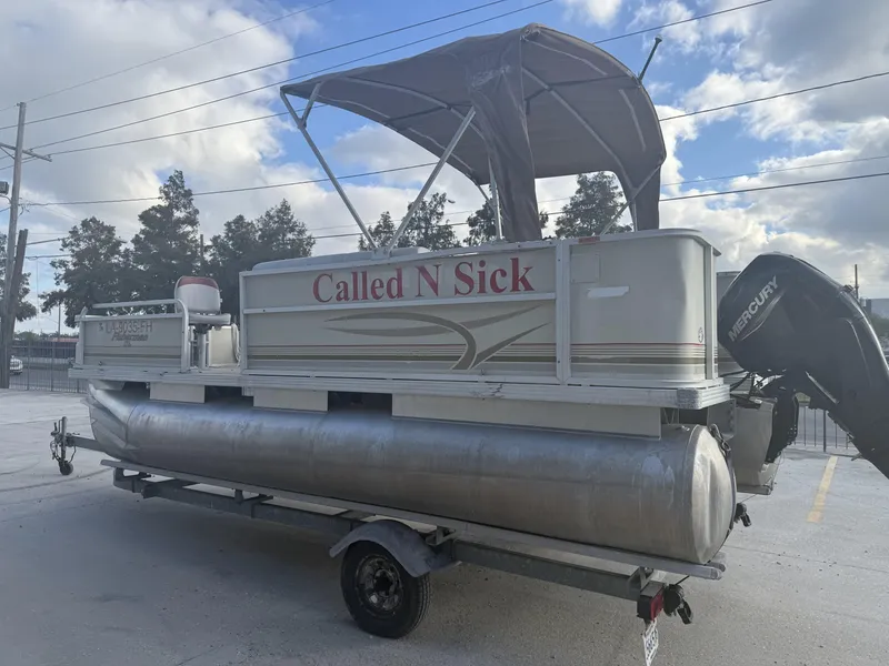 Slide: The Image of 2003 Crest 18 Fisherman pontoon boat with canopy, named "Called N Sick," on a trailer. - 3