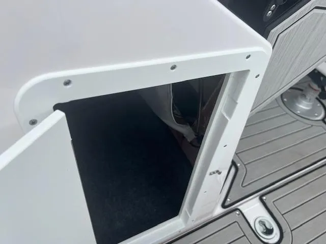 Slide: The Image of 2024 Yamaha Boats 252 S storage compartment with open door on deck. - 13