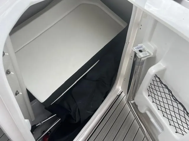 Slide: The Image of 2024 Yamaha Boats 252 S storage compartment with cushioned interior and netted pocket. - 14