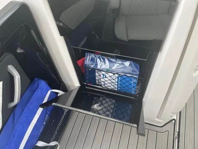 Slide: The Image of 2024 Yamaha Boats 252 S interior storage compartment with netting and seating. - 20