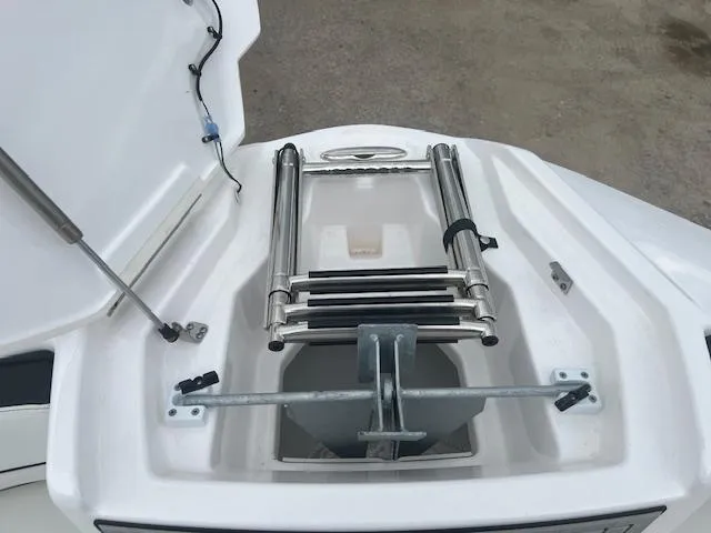 Slide: The Image of 2024 Yamaha Boats 252 S anchor compartment with ladder, open hatch view. - 6